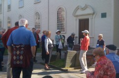 A tour stops outside Trinity Church to discuss the building’s architectural significance.
