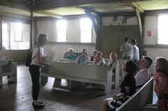 A tour group rests inside the 1699 Great Friends Meeting House.