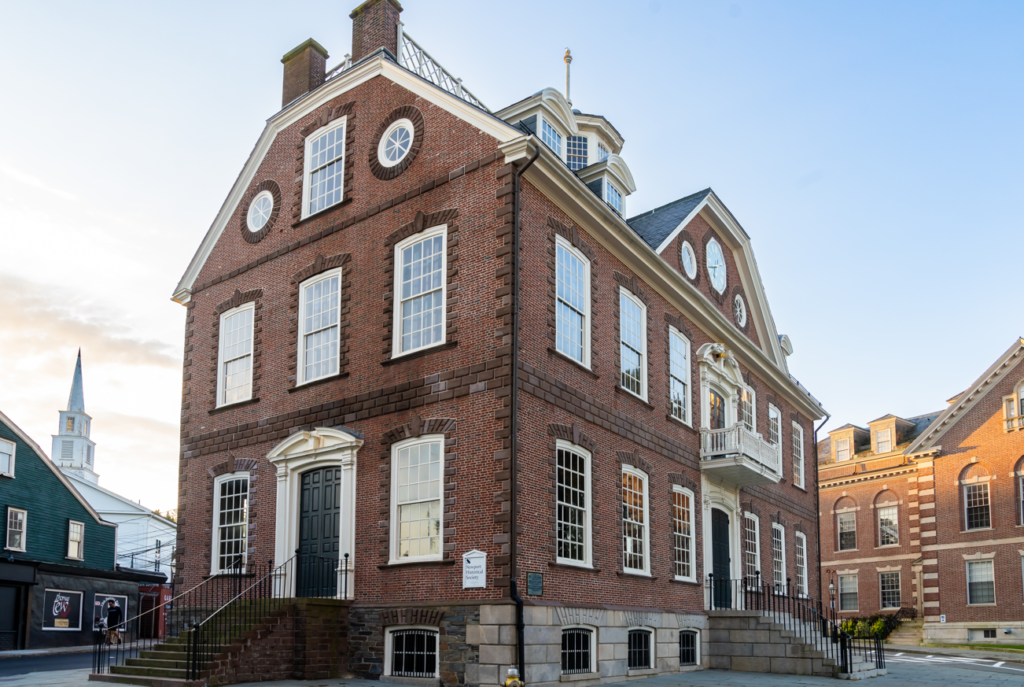 A view of the Colony House on Washington Square in Newport, Rhode Island. A white sign on the building's exterior reads "Newport Historical Society"