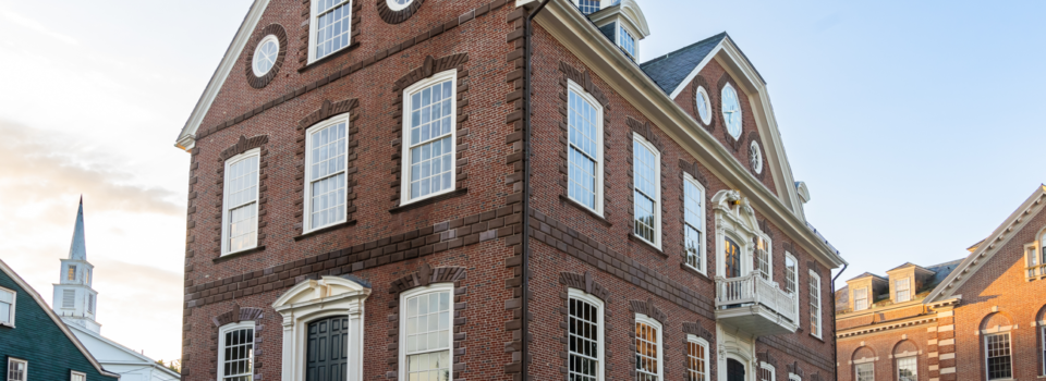 A view of the Colony House on Washington Square in Newport, Rhode Island. A white sign on the building's exterior reads "Newport Historical Society"